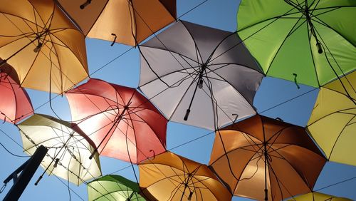 Low angle view of colorful umbrellas against clear sky