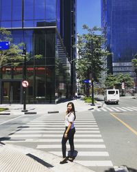 Full length of woman on street against buildings in city