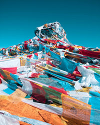 Low angle view of multi colored umbrellas against blue sky