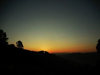 Silhouette landscape against clear sky during sunset