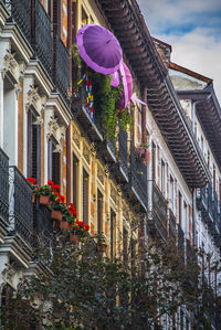 Low angle view of building by houses against sky