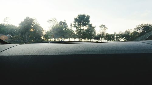 Road amidst trees seen through car windshield