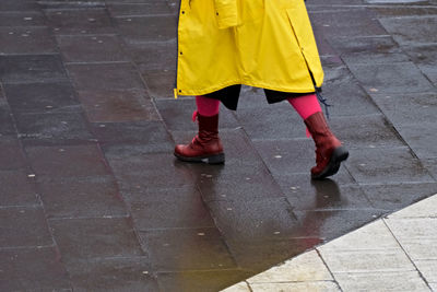 Low section of man on wet yellow surface