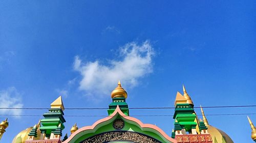 Low angle view of multi colored building against blue sky