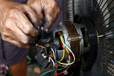 Midsection of man working on metal