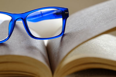 Blue eyeglasses on book at table