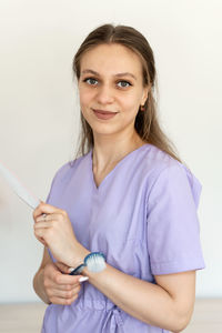 Portrait of young woman holding thermometer