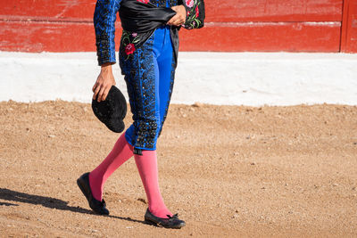 Low section of woman walking on road