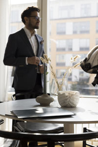 Agreement files on table with salesman in background at home