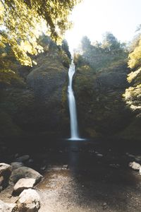 Scenic view of waterfall against sky