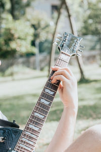 Cropped hand of man playing guitar