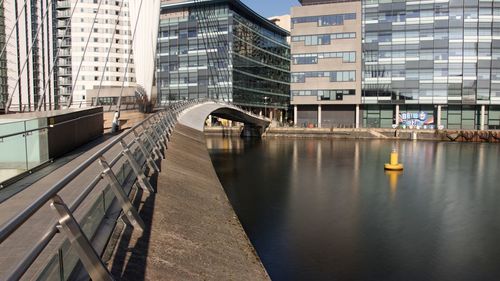 Bridge over river by buildings in city