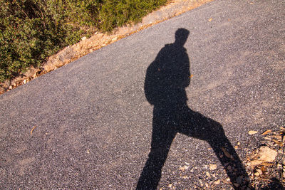 Shadow of man on road