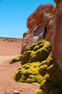 View of rocks in desert against clear blue sky
