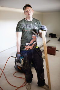 Full length portrait of confident carpenter standing at site