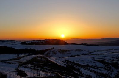 Scenic view of snowcapped mountains against sky during sunset