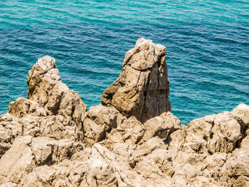 Rocks in sea against sky