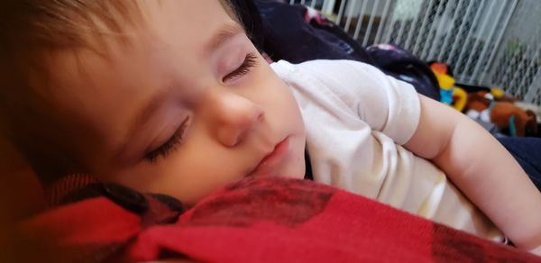 Close-up portrait of cute baby sleeping on bed