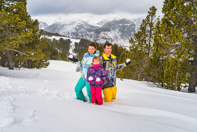 Family holding snowballs and are ready for a snow fight. ski winter holidays in andorra