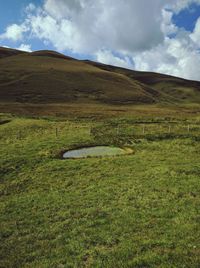 Countryside landscape against cloudy sky