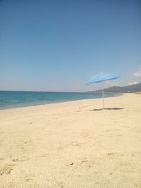 Scenic view of beach against blue sky