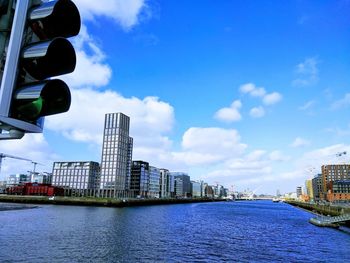 Modern buildings by river against sky in city at canal dock in dublin 2