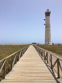 Pathway leading to lighthouse on landscape