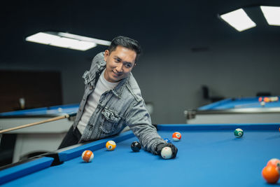 Portrait of woman playing pool