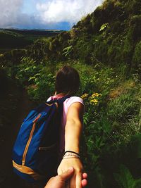 Rear view of woman on tree against sky