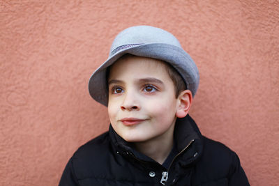 Portrait of boy standing against wall