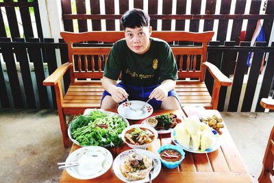 Portrait of woman having food at table in restaurant