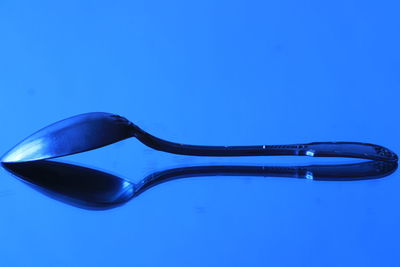 Close-up of spoon against blue background