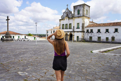 Rear view of woman standing against building