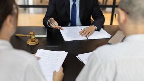 Midsection of business colleagues working on table