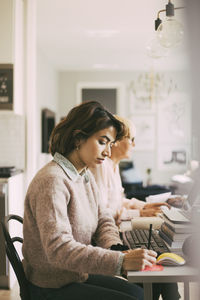 Two women working in living room at home