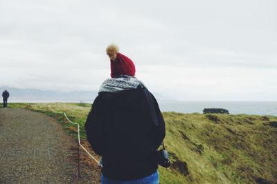 Rear view of woman standing on footpath against clear sky at snaefellsnes