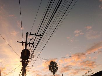 Low angle view of silhouette electricity pylon against sky