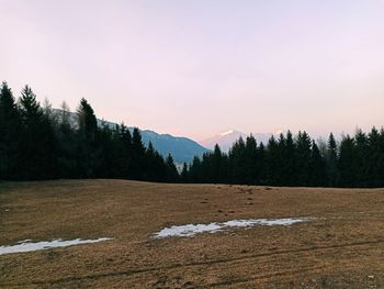 Scenic view of snow covered land against sky during sunset