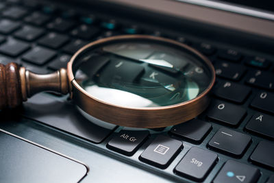 Close-up of magnifying glass laptop keyboard