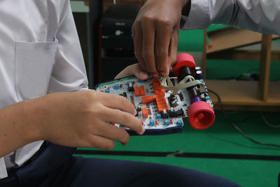 Close up of hands while assembling the robot.