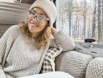 Portrait of young woman sitting on sofa at home