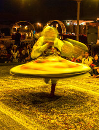 Illuminated carousel in amusement park at night