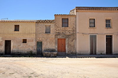 Abandoned building in town against clear sky