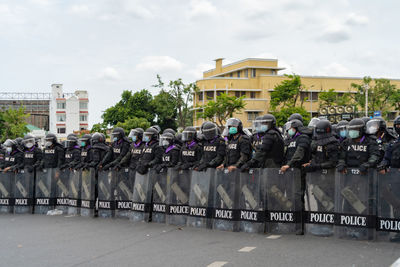 Group of people in town square against sky