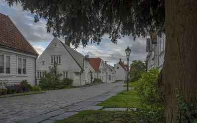 Footpath amidst buildings against sky