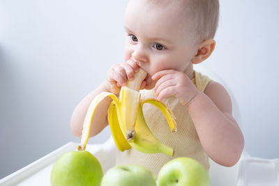 Cute girl eating banana at home