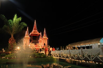 Illuminated building against sky at night