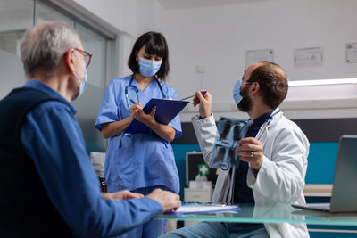 Doctor discussing with female nurse at clinic