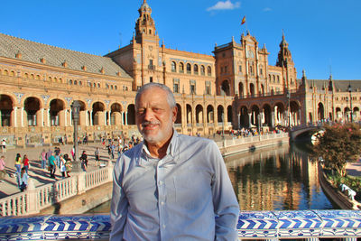 Portrait of man standing against historical building