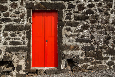 Closed red door of stone building